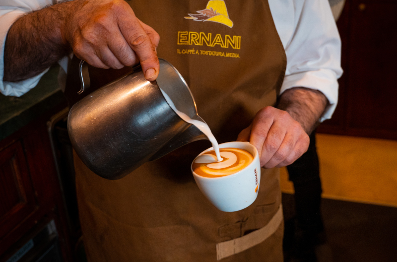Foto ad Andrea, Barista della Torrefazione Ernani, mentre prepara un cappuccino.